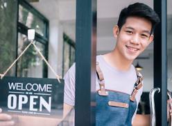 Decorate image, cafe owner at the door with a welcome open sign